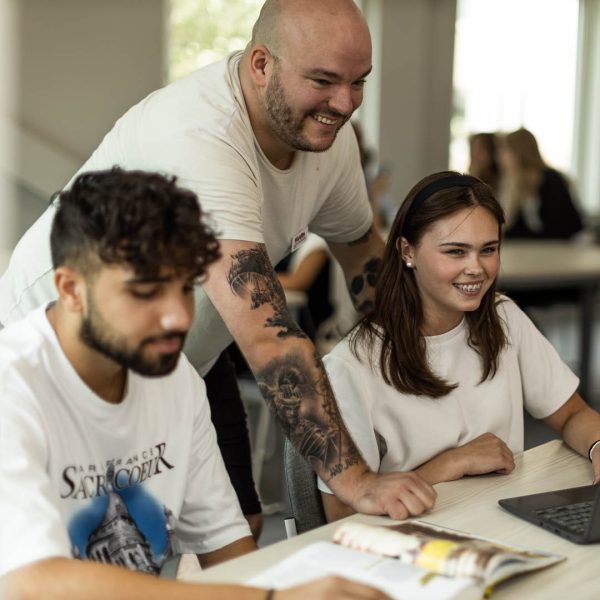 Larare hjalper tva elever med en uppgift i ett klassrum