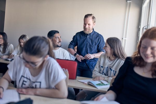 Larare i ett klassrum hjalper sina elever som tacksamt tar emot hjalp.
