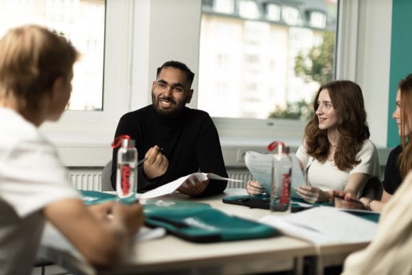 En grupp elever diskuterar tillsammans en uppgift i klassrummet.